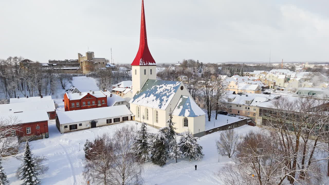 Aerial view circling the snowy church, sunny, winter day in Rakvere, Estonia