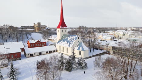 aerial view circling the snowy church, sunny, winter day in rakvere, estonia