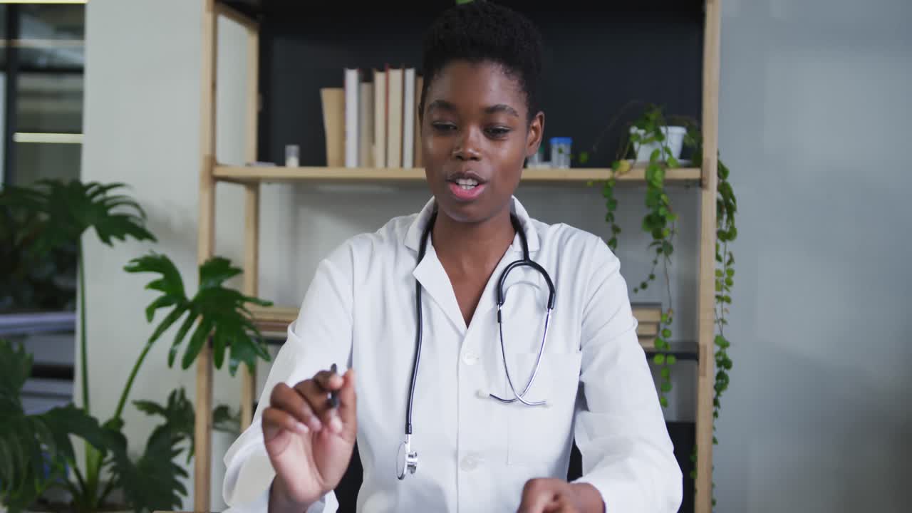 retrato de una doctora afroamericana que tiene un chat de video hablando y sonriendo