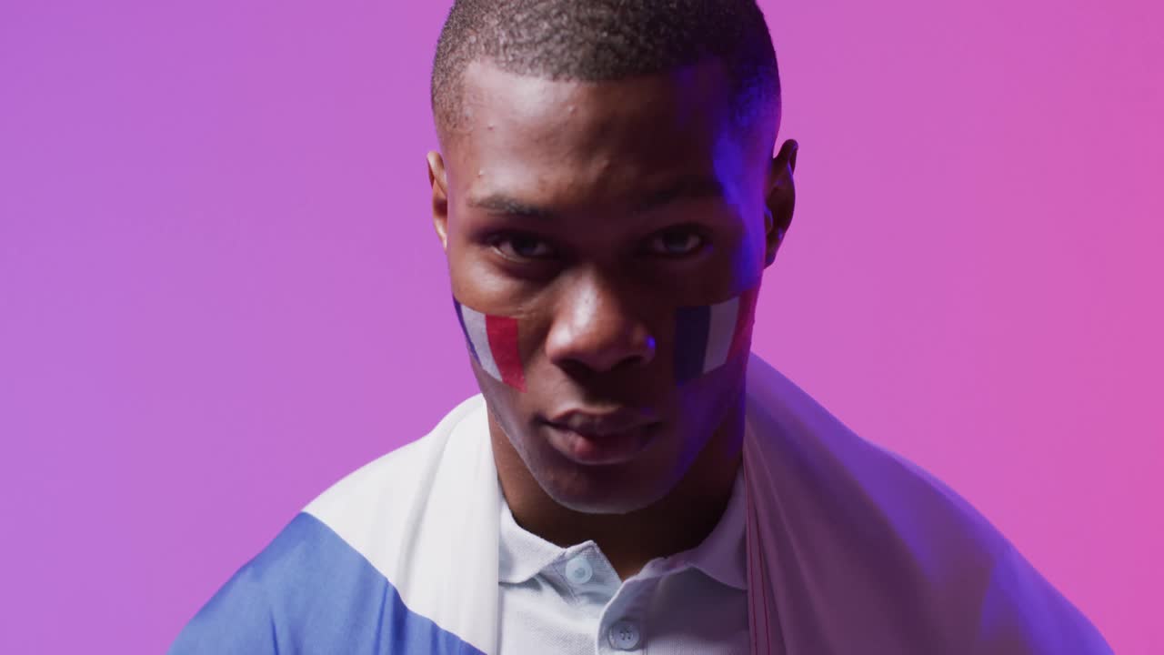 핑크색 조명 위에 프랑스의  ⁇ 발을 가진 아프리카계 미국 남성 축구 팬의 초상화