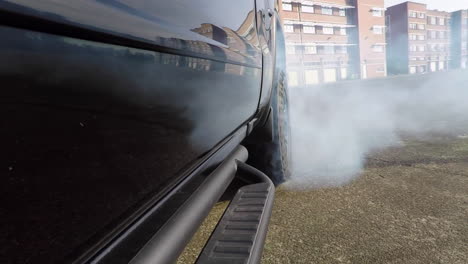 toma del neumático trasero de un camión negro que se quema en un estacionamiento abandonado