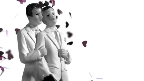 Confetti-falling-on-gay-groom-cake-toppers-in-black-and-white