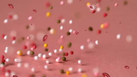 Animation-of-balls-falling-over-sprinkles-on-pink-background