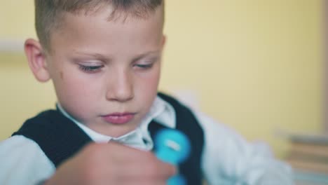 kid plays with turning spinner resting at break in classroom