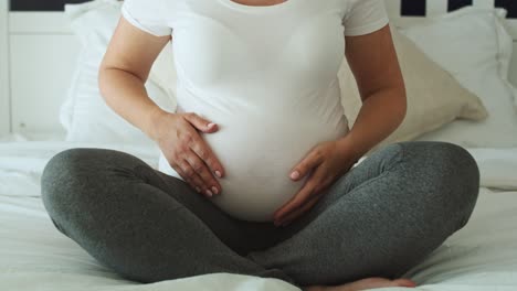 video estático de una mujer embarazada acariciando su abdomen avanzado.