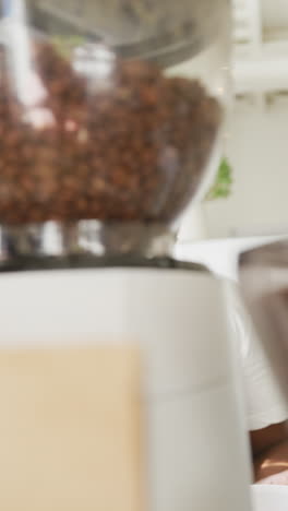 video vertical de un barista afroamericano preparando café en una cafetería