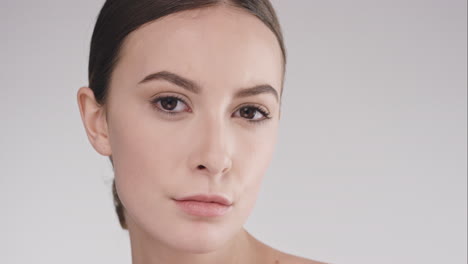 Beauty-portrait-of-woman-with-beautiful-face-tilting-head-up-slow-motion-skincare-concept-on-a-grey-background-slow-motion-Red-Epic-Dragon