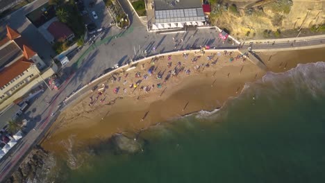 Aerial,-pan,-drone-shot,-panning-around-the-Estoril-cityscape,-the-Forte-da-cruz-castle,-Tamariz-Beach-and-backwards-the-beach,-on-a-sunny-evening,-on-the-coast-of-Portugal