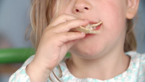 un primer plano de una chica comiendo un paquete de papas fritas