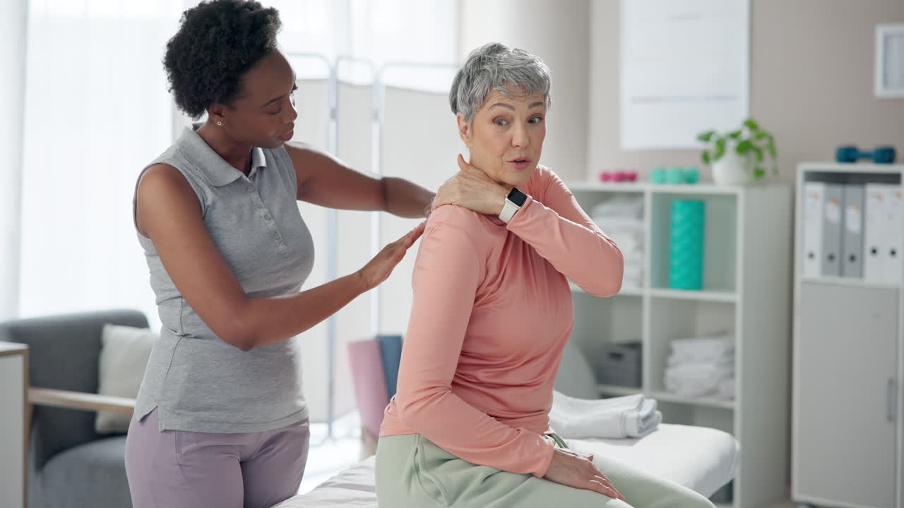 Physical therapist giving massage to senior woman