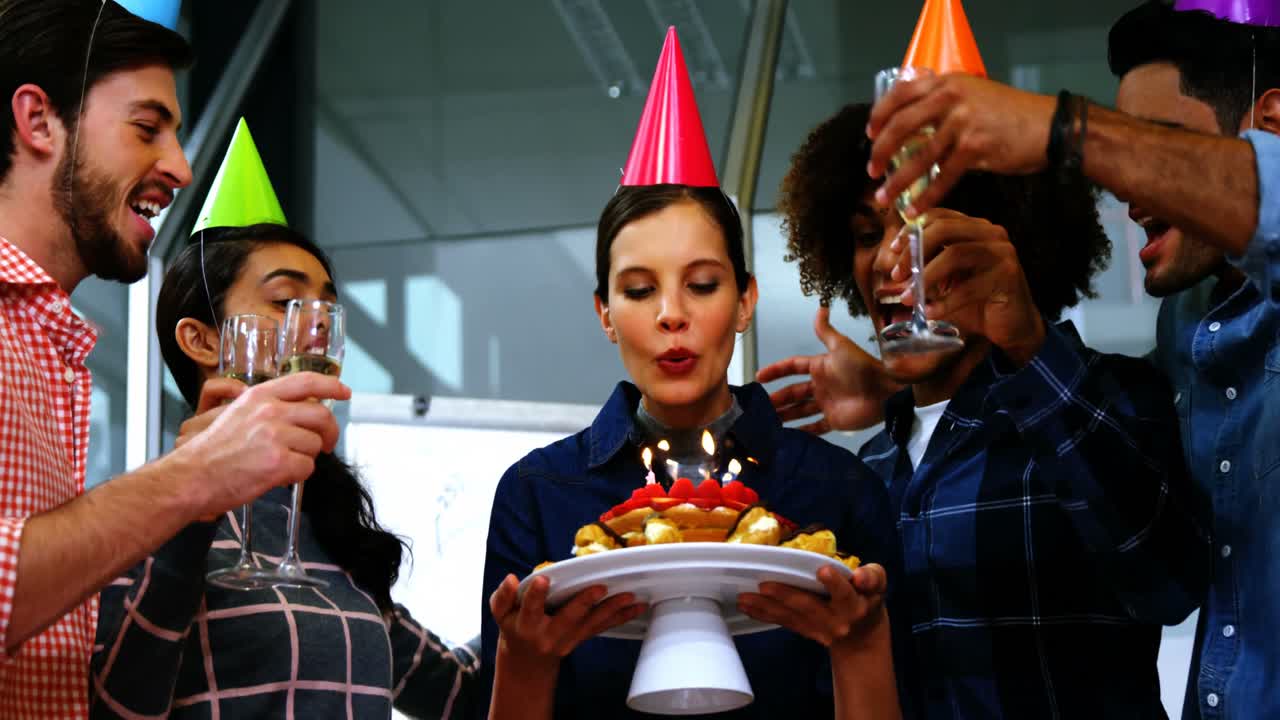 felices ejecutivos celebrando el cumpleaños de sus colegas.