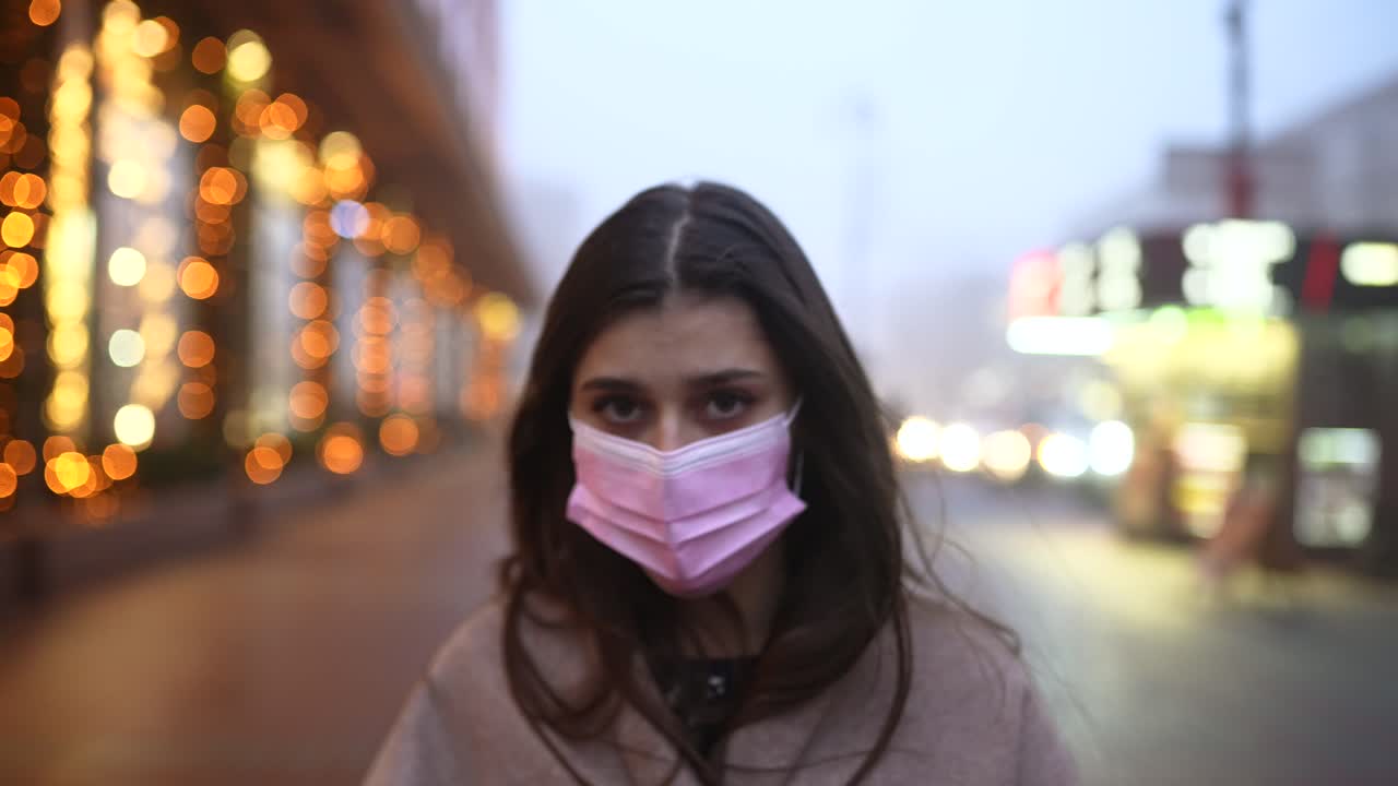 밤 에 도시 거리 에서 마스크 를 착용 한 여자