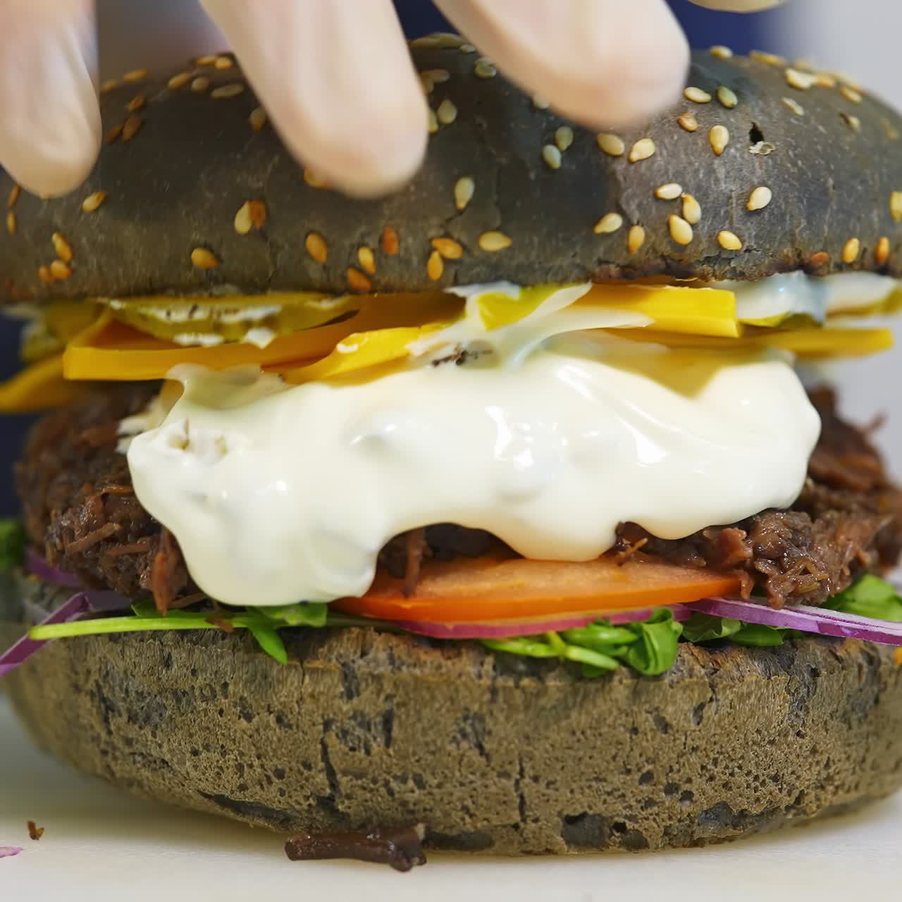 Tasty brown burger prepared by a professional chef. Burger prepared. Fresh tasty burger with cheese and vegetables. Close-up