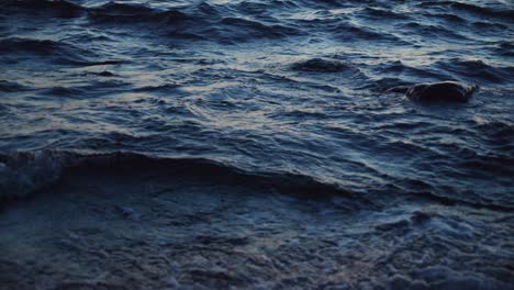 beautiful blue waves moving, crashing on the sea shore in the dusk