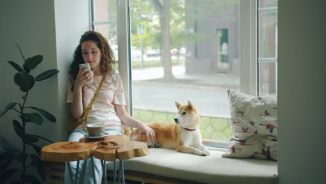 young woman with dog in a cafe