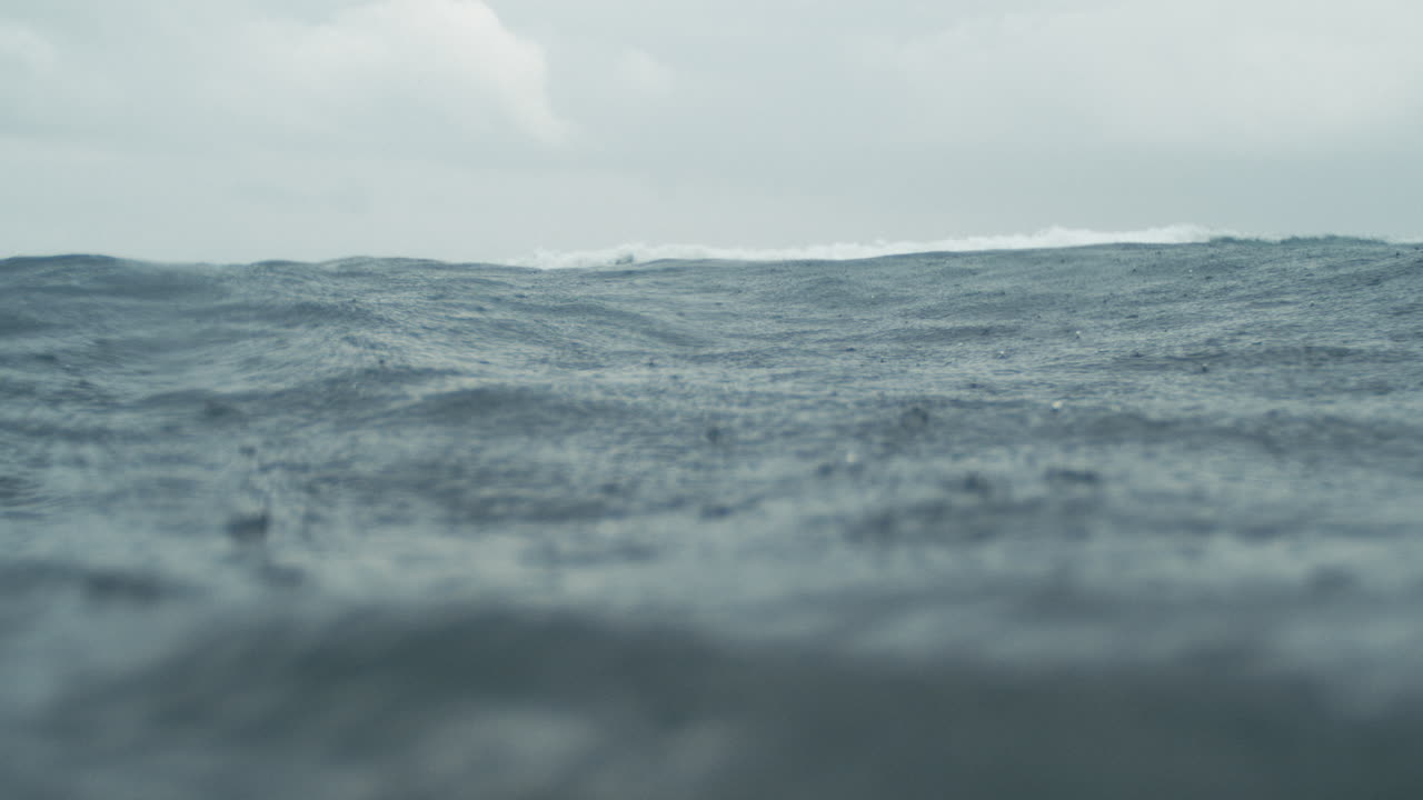 Detailed in water establishing of raindrops falling in super slow motion on ocean
