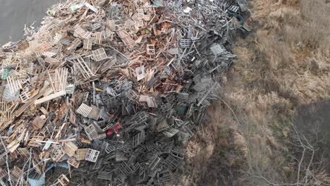 toma aérea de paletas de madera abandonadas en un vertedero de basura, recolección de recuperación de vertederos