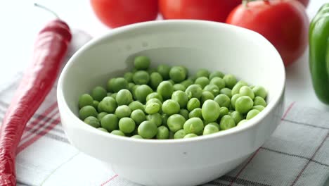 fresh green peas in a bowl with vegetables