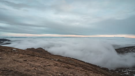 Nubes-Expansivas-Ruedan-Sobre-Un-Pico-Escarpado-Durante-Una-Toma-De-Tiempo-Serena-Y-De-Gran-Angular