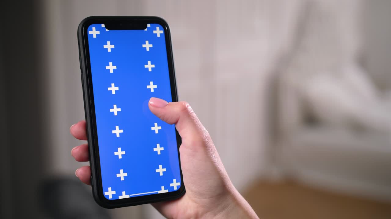 mujer se desliza, se desplaza hacia arriba y hacia abajo pantalla clave de croma azul en la aplicación de teléfono inteligente.