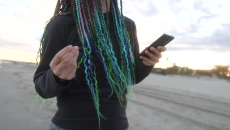 woman-with-colorful-braids-and-mobile-phone-with-music