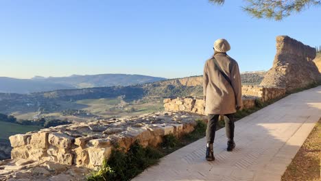 hand-held tracking shot of a tourist walking around in ronda, spain