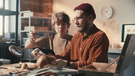 two researchers examining ancient skull in archaeology laboratory