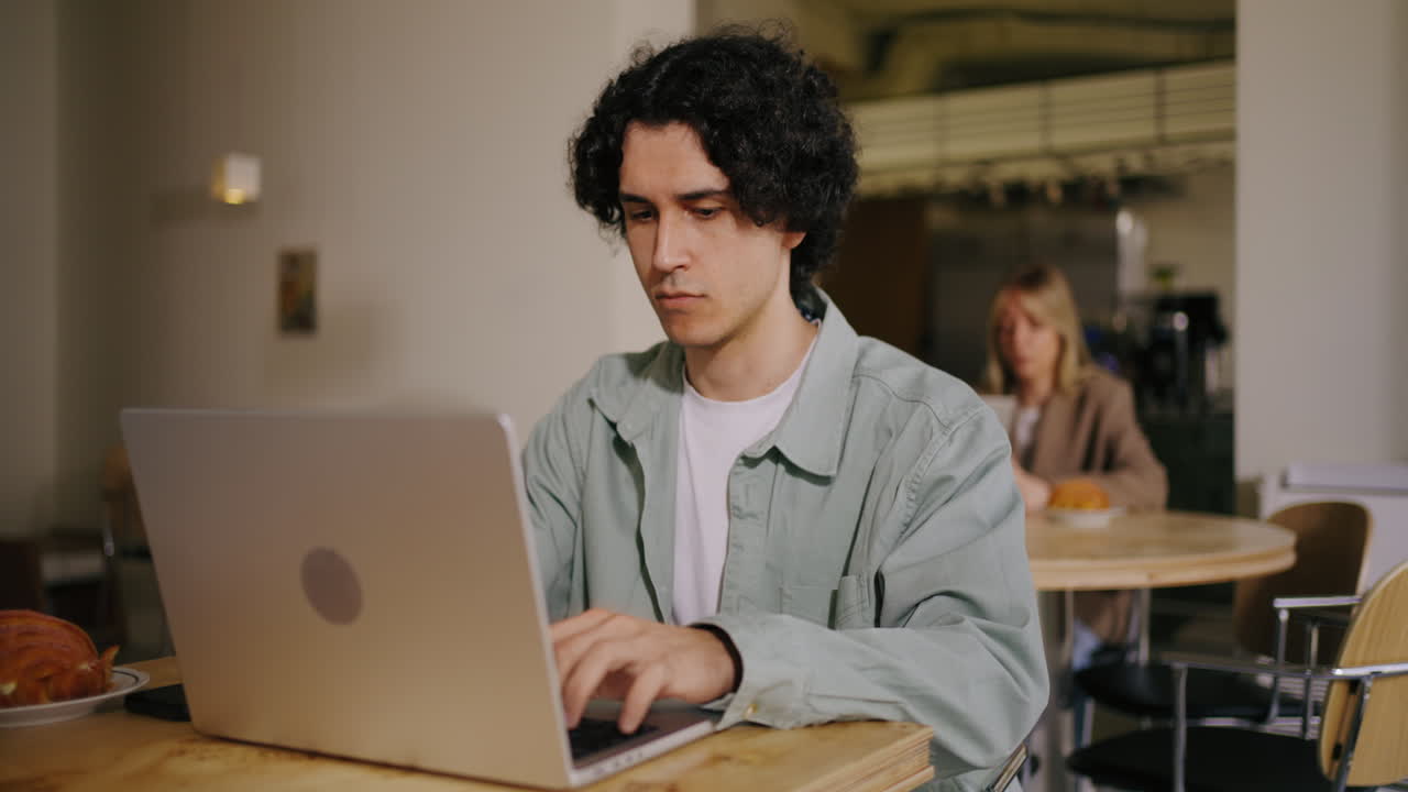 un hombre trabajando en su portátil en una cafetería
