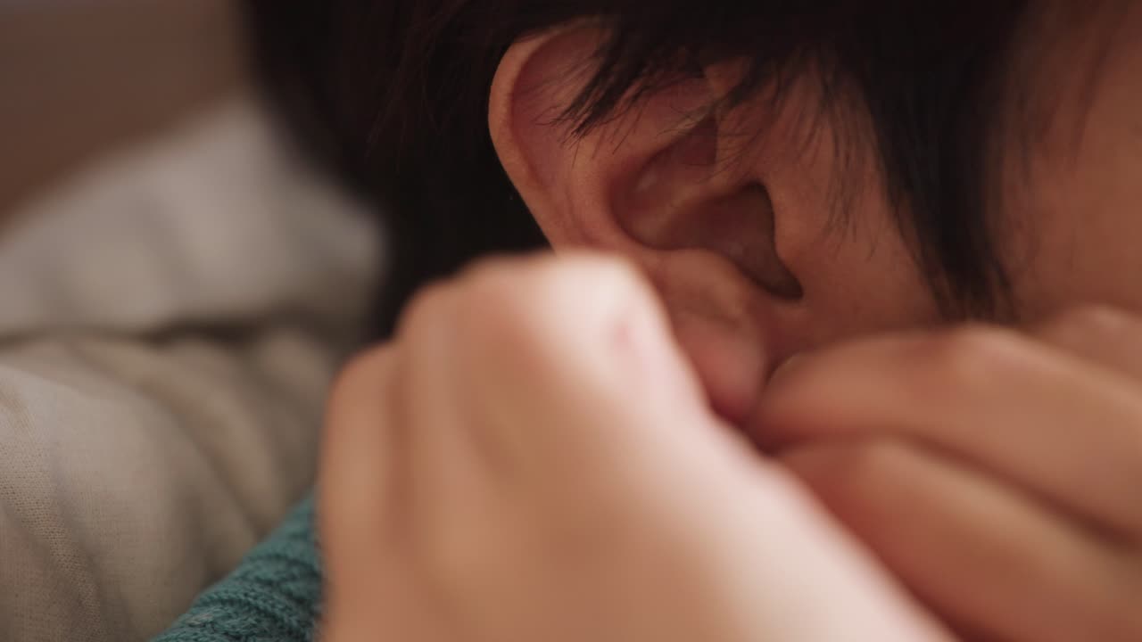 mujer del sur de asia con el pelo corto poniéndose un aro de oro