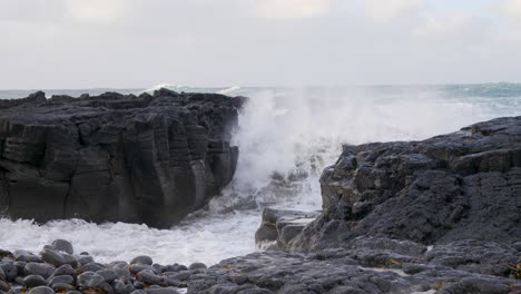 Waves-crashing-on-Iceland's-black-basalt-rock-coast,-cloudy-sky,-dynamic-ocean-scene