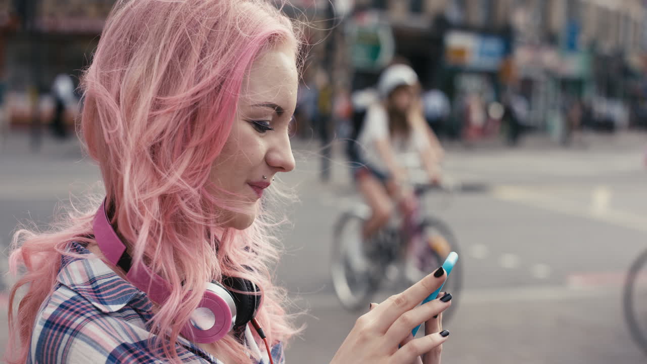 Slow Motion Portrait of caucasian girl with pink hair using smart phone