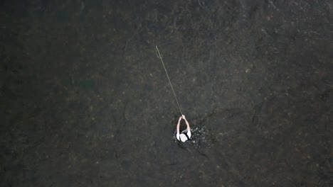 bird's eye drone shot above a man fly fishing in the provo river in the mountains of utah-2