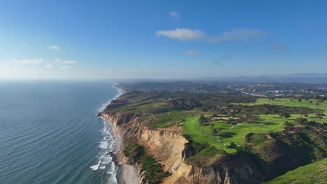 aerial view panning up looking at torrey pines golf course and blacks beach in san diego near del mar and la jolla with a great view of the cliffs ocean and gliderport