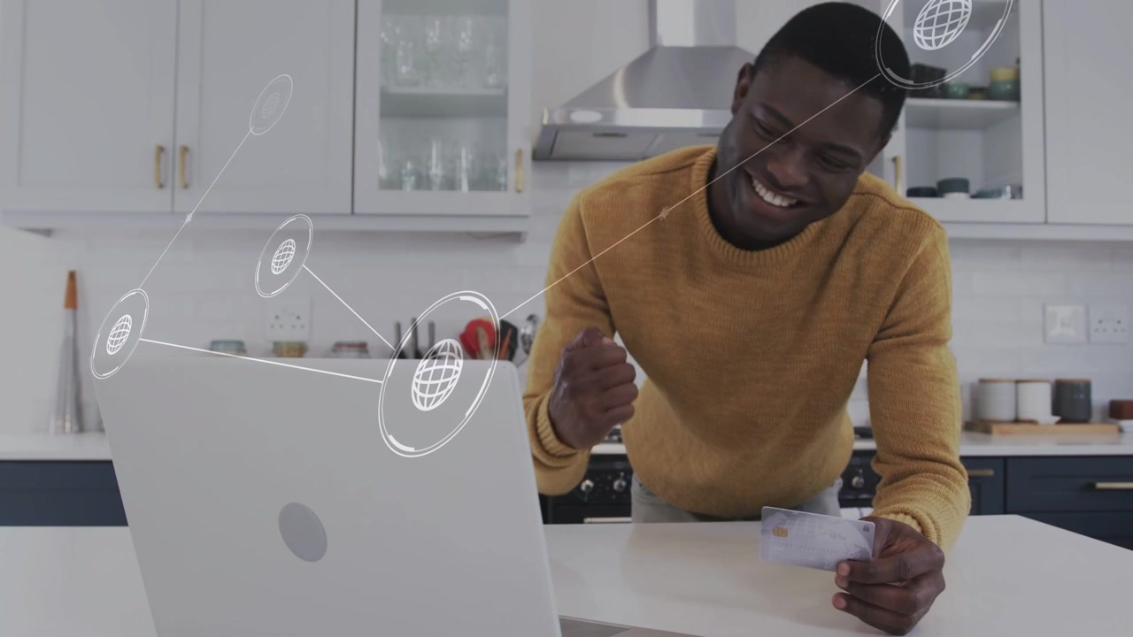 Man at island holding receipt tapping laptop, network rings appearing, smiling then checking bills