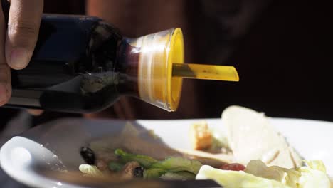 pouring dressing on caesar salad