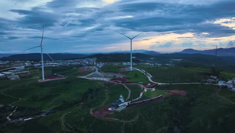 Drone-view-wind-turbine-in-sunset-on-Cau-Dat-tea-hill-of-Da-Lat,-Lam-Dong-province,-central-highlands-Vietnam