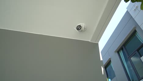 white outdoor cctv camera on celling, no people