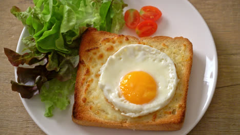 homemade bread toasted with cheese and fried egg on top with vegetable salad for breakfast