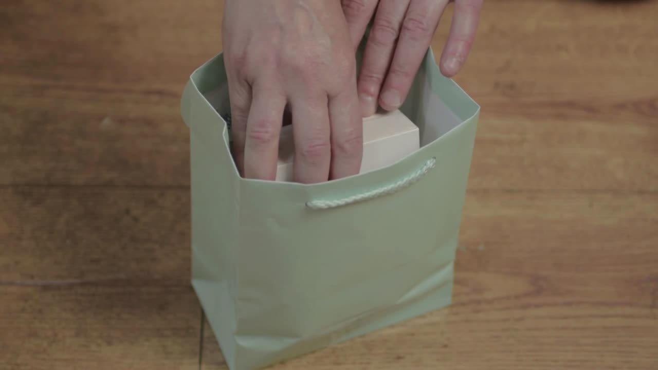 mujer sacando una caja de regalo de una bolsa de regalo