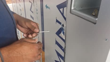 hombre cerrando la puerta de hoja compuesta con la llave de la máquina expendedora de agua k casa
