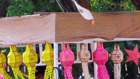 a close-up view of colorful lanterns hanging beneath a patterned canopy in an outdoor setting.