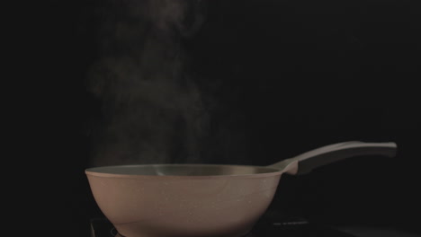 de pie solo en la sartén con humo saliendo y fondo negro filmado en 4k crudo