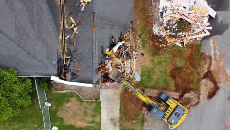 an excavator tearing down the corner of a building