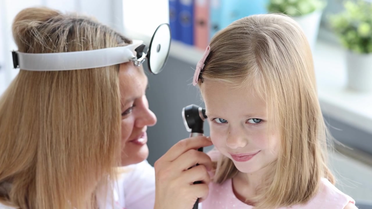 Ent doctor examining little girl ear using otoscope 4k movie slow motion
