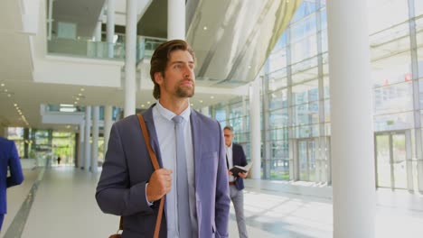 Caucasian-businessman-walking-in-the-lobby-at-office-4k