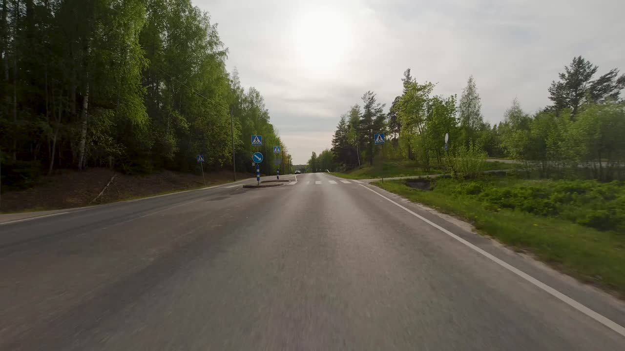 дорога простирается вперед, окруженная пышными зелеными деревьями с обеих сторон