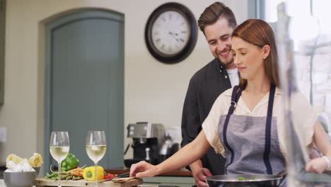 couple cooking together in kitchen