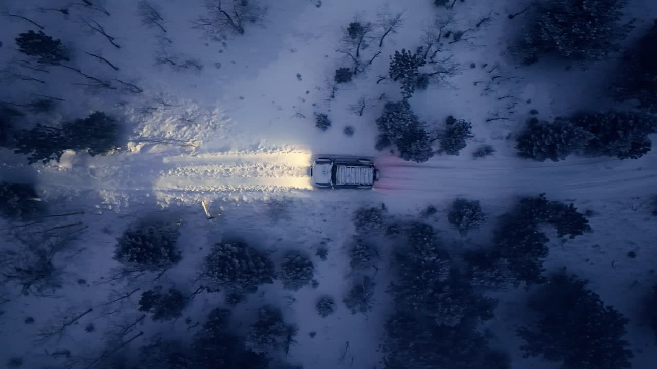 Aerial perspective of SUV traveling snowy trail at twilight, serene blue hour winter landscape