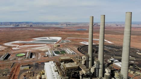 A-drone-shot-of-the-“Navajo-Generating-Station”,-a-massive-coal-fired-power-plant-and-industrial-complex-with-tall-stacks,-in-the-middle-of-the-desert-of-the-Navajo-Nation,-located-near-Page,-Arizona