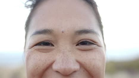 smiling woman enjoying outdoor mountain hike, close-up of face with freckles